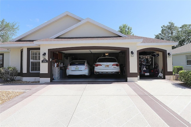 entrance to property with roof with shingles, driveway, a garage, and stucco siding