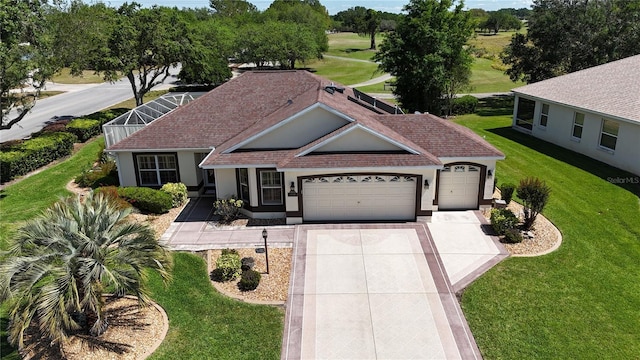 view of front of property featuring concrete driveway, stucco siding, an attached garage, a front lawn, and a shingled roof