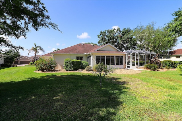 rear view of house featuring a lawn and stucco siding