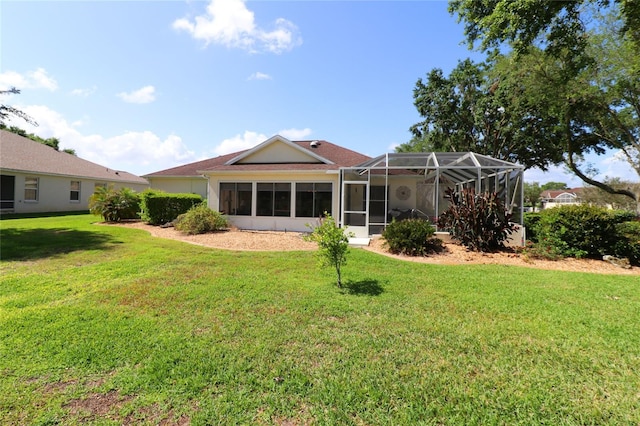 back of property with a lanai and a lawn