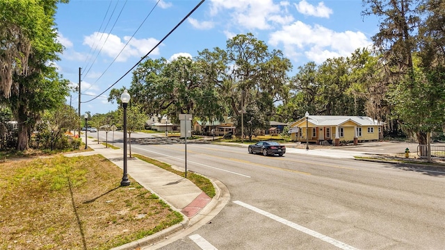 view of road with street lighting, sidewalks, and curbs