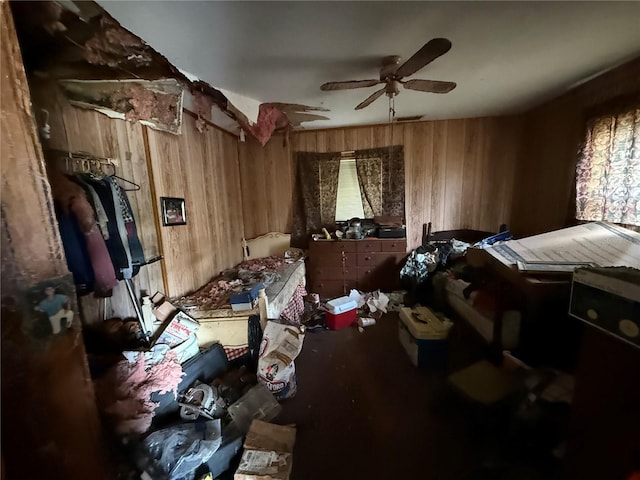 bedroom featuring wooden walls and ceiling fan