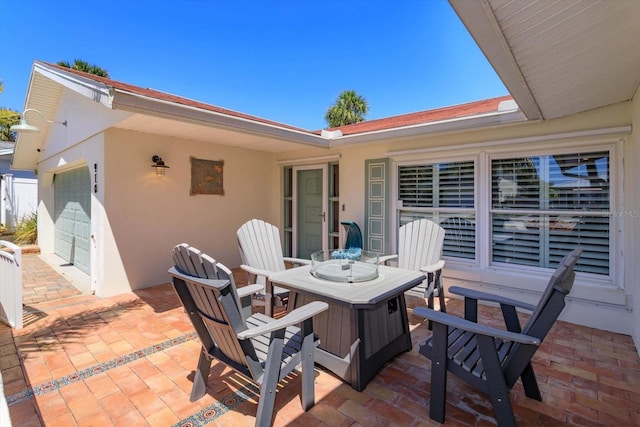 view of patio featuring outdoor dining area and a garage