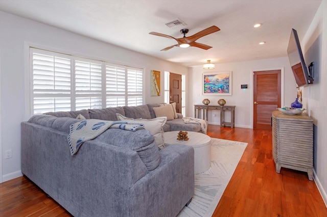 living area with a ceiling fan, wood finished floors, baseboards, and recessed lighting