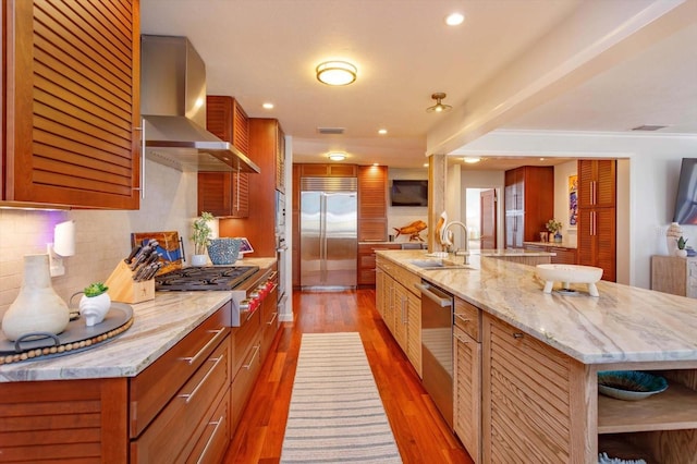 kitchen with wall chimney range hood, appliances with stainless steel finishes, a sink, decorative backsplash, and open shelves