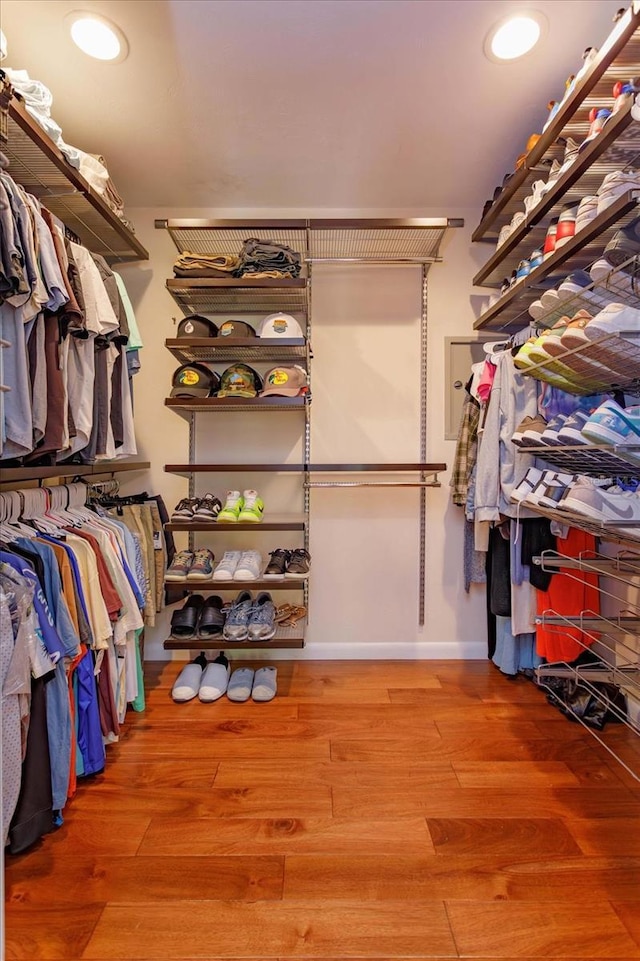 walk in closet with wood finished floors