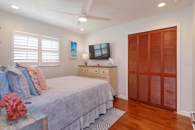 bedroom with wood finished floors, a closet, recessed lighting, a ceiling fan, and baseboards