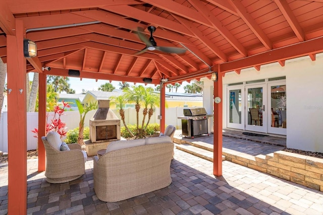view of patio / terrace with an outdoor fireplace, french doors, a grill, fence, and ceiling fan