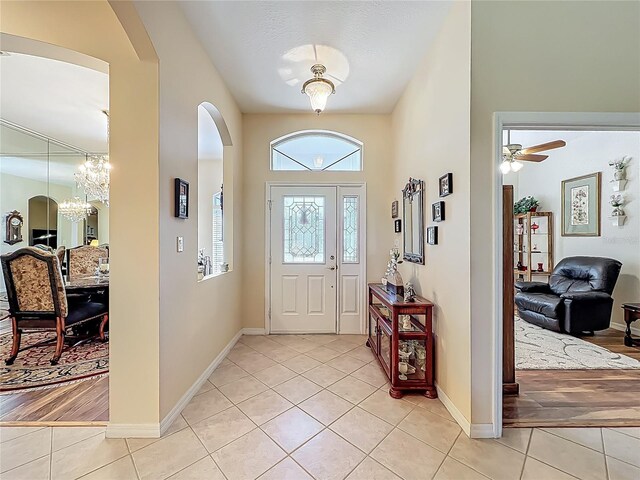 25523 Maurepas Ln, Leesburg, FL 34748 - entryway with arched walkways, light tile patterned floors, and baseboards