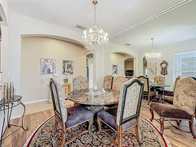 25523 Maurepas Ln, Leesburg, FL 34748 - dining room with arched walkways, an inviting chandelier, and visible vents