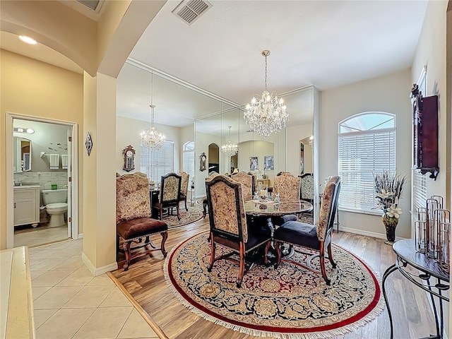 25523 Maurepas Ln, Leesburg, FL 34748 - dining space with a chandelier, arched walkways, light tile patterned flooring, and visible vents