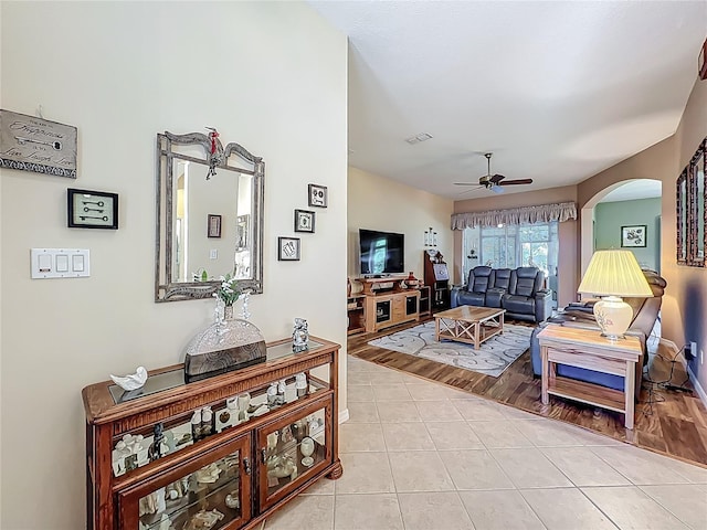 25523 Maurepas Ln, Leesburg, FL 34748 - living area featuring arched walkways, light tile patterned floors, a ceiling fan, and visible vents