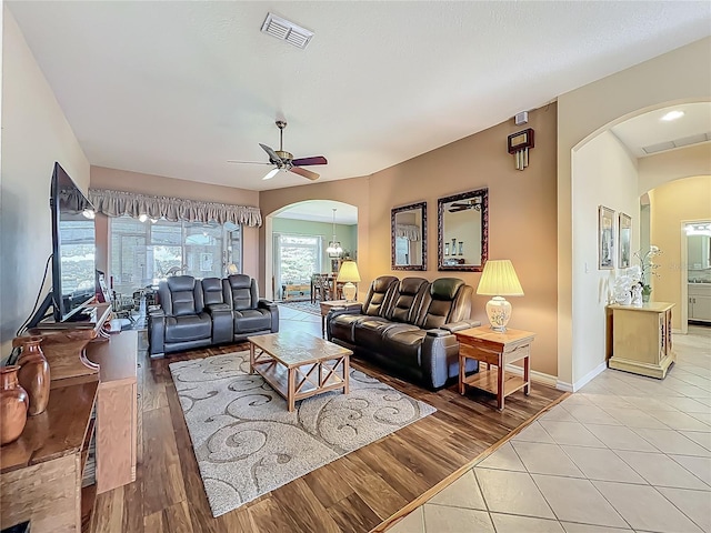 25523 Maurepas Ln, Leesburg, FL 34748 - living area featuring arched walkways, ceiling fan, visible vents, and light wood-type flooring