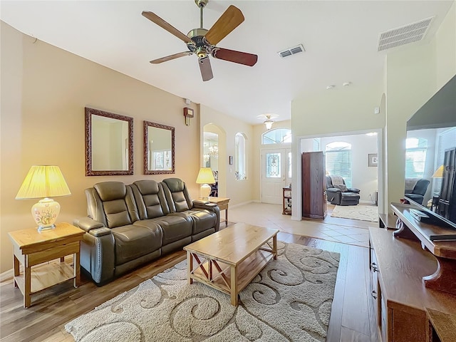 25523 Maurepas Ln, Leesburg, FL 34748 - living room with light wood-style flooring, visible vents, ceiling fan, and arched walkways