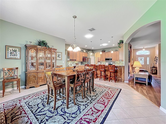 25523 Maurepas Ln, Leesburg, FL 34748 - dining space featuring light tile patterned floors, visible vents, arched walkways, an inviting chandelier, and recessed lighting