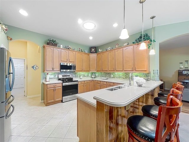 25523 Maurepas Ln, Leesburg, FL 34748 - kitchen featuring tasteful backsplash, arched walkways, a peninsula, and stainless steel appliances