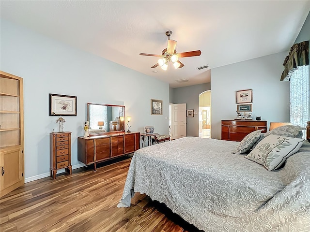 25523 Maurepas Ln, Leesburg, FL 34748 - bedroom featuring baseboards, visible vents, ceiling fan, arched walkways, and wood finished floors