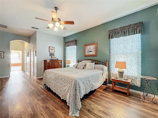 25523 Maurepas Ln, Leesburg, FL 34748 - bedroom featuring arched walkways, visible vents, baseboards, and wood finished floors