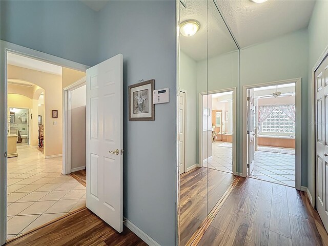 25523 Maurepas Ln, Leesburg, FL 34748 - hallway featuring arched walkways, wood finished floors, and baseboards