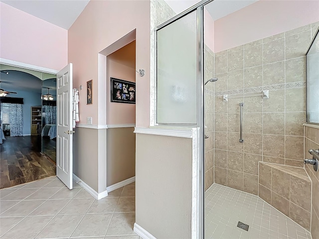 25523 Maurepas Ln, Leesburg, FL 34748 - ensuite bathroom featuring ceiling fan, connected bathroom, a shower stall, tile patterned flooring, and baseboards