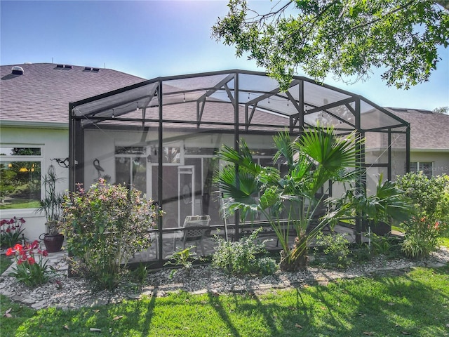 25523 Maurepas Ln, Leesburg, FL 34748 - rear view of house with a lanai, roof with shingles, and stucco siding