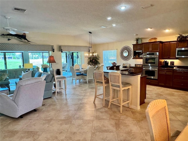1985 Abordale Ln, The Villages, FL 32162 - kitchen featuring dark countertops, open floor plan, appliances with stainless steel finishes, and a textured ceiling