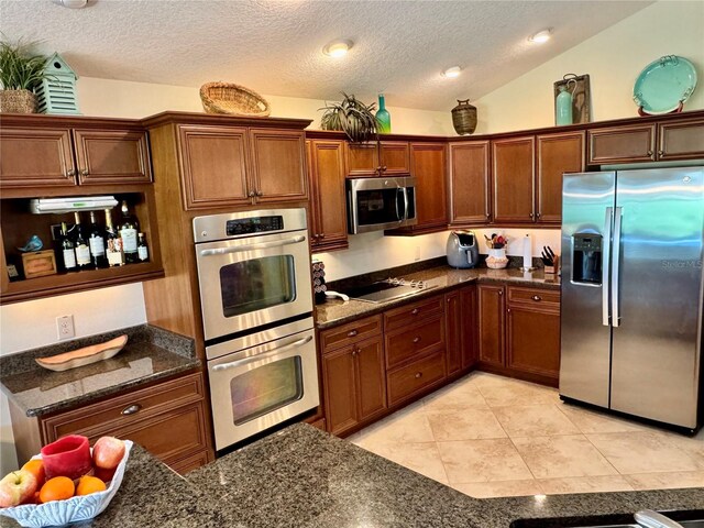 1985 Abordale Ln, The Villages, FL 32162 - kitchen with a textured ceiling, light tile patterned floors, vaulted ceiling, and stainless steel appliances