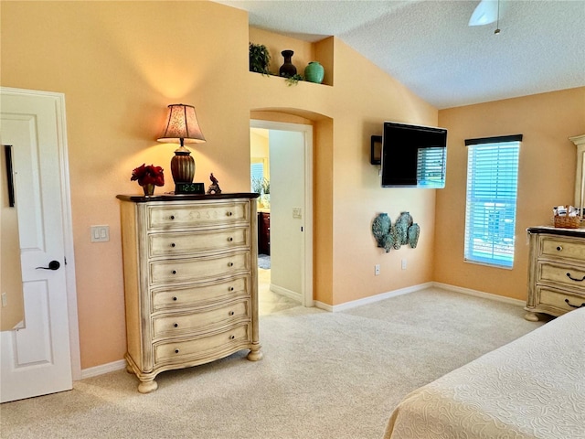 1985 Abordale Ln, The Villages, FL 32162 - bedroom featuring baseboards, a textured ceiling, lofted ceiling, arched walkways, and light colored carpet