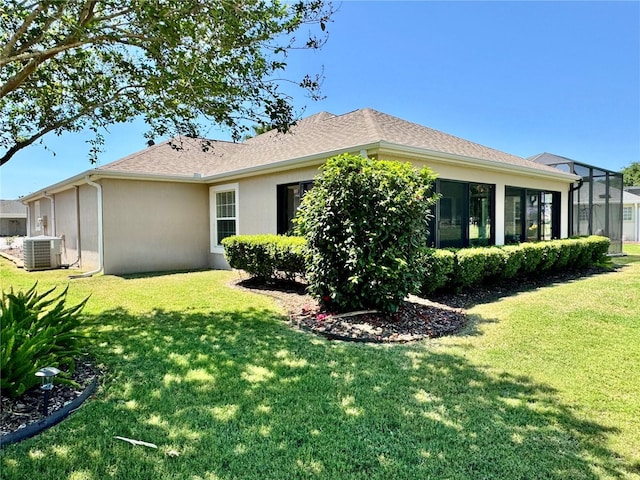 1985 Abordale Ln, The Villages, FL 32162 - rear view of house with a yard, stucco siding, cooling unit, and a shingled roof