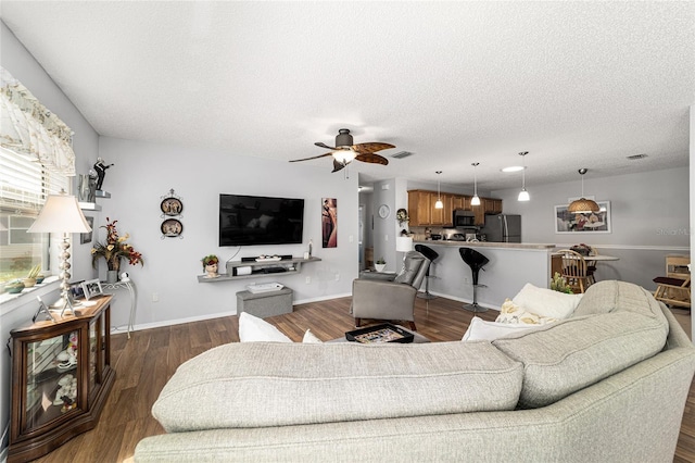 312 Emmalee Pl, The Villages, FL 32162 - living room with visible vents, a textured ceiling, a ceiling fan, and dark wood-style floors