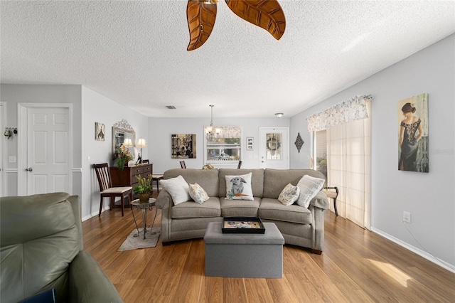 312 Emmalee Pl, The Villages, FL 32162 - living room featuring baseboards, an inviting chandelier, and wood finished floors
