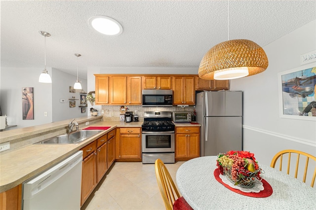 312 Emmalee Pl, The Villages, FL 32162 - kitchen featuring tasteful backsplash, a textured ceiling, appliances with stainless steel finishes, light countertops, and a sink