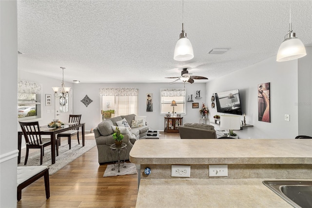 312 Emmalee Pl, The Villages, FL 32162 - living room with ceiling fan with notable chandelier, dark wood-style floors, and a textured ceiling