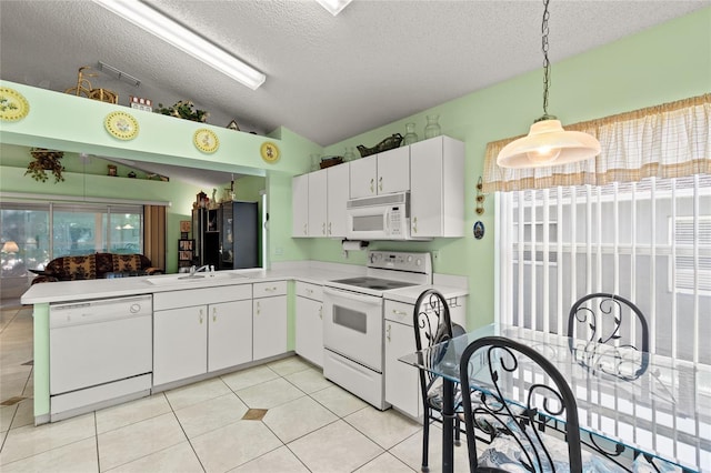 3603 Westerham Dr, Clermont, FL 34711 - kitchen featuring vaulted ceiling, white appliances, light countertops, a textured ceiling, and white cabinets
