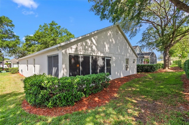 3603 Westerham Dr, Clermont, FL 34711 - view of side of home with stucco siding, glass enclosure, and a lawn