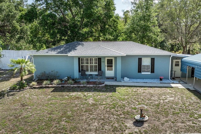 single story home featuring stucco siding, a patio area, a front yard, fence, and a shingled roof