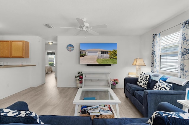 living area with ceiling fan, baseboards, light wood-style floors, and visible vents