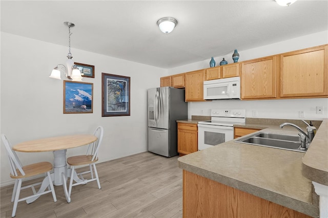 kitchen with a sink, white appliances, light wood-type flooring, baseboards, and hanging light fixtures