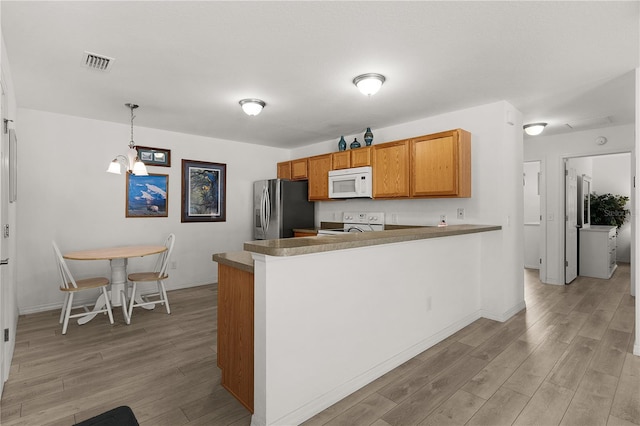 kitchen featuring a peninsula, visible vents, light wood-style floors, white appliances, and pendant lighting