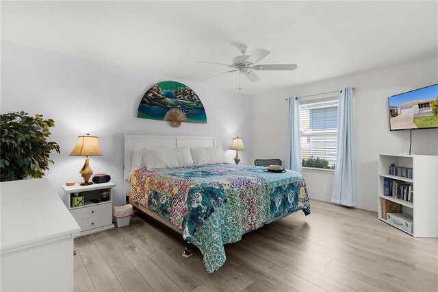 bedroom featuring ceiling fan, baseboards, and light wood-style flooring