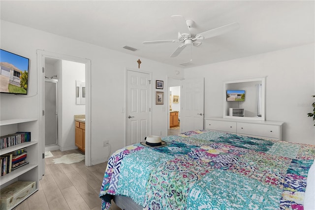 bedroom with a ceiling fan, ensuite bathroom, visible vents, and light wood-type flooring