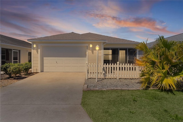 single story home with driveway, fence, a yard, and a garage