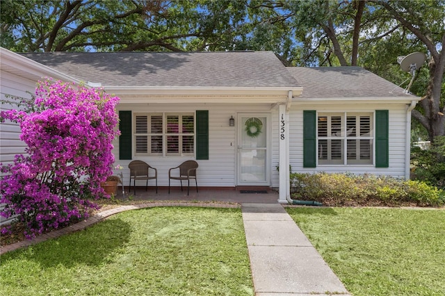 1358 E Schwartz Blvd, The Villages, FL 32159 - view of front of house with a shingled roof, a porch, and a front yard