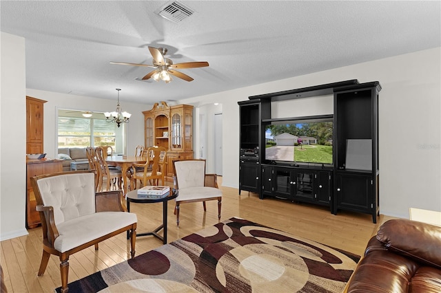 1358 E Schwartz Blvd, The Villages, FL 32159 - living room featuring visible vents, a textured ceiling, light wood-style floors, and ceiling fan with notable chandelier