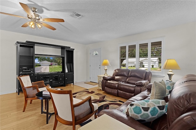 1358 E Schwartz Blvd, The Villages, FL 32159 - living area with visible vents, baseboards, a textured ceiling, a ceiling fan, and light wood-style flooring