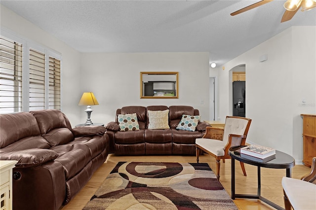 1358 E Schwartz Blvd, The Villages, FL 32159 - living room with arched walkways, ceiling fan, light wood-type flooring, and a textured ceiling