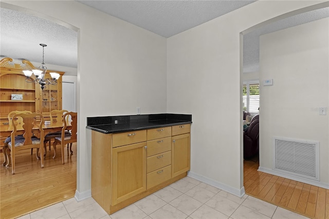 1358 E Schwartz Blvd, The Villages, FL 32159 - kitchen featuring arched walkways, a textured ceiling, visible vents, and an inviting chandelier