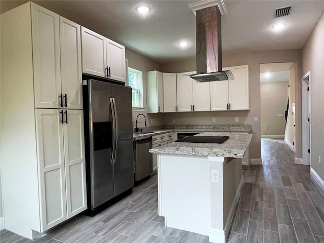 kitchen with island range hood, light wood-style flooring, visible vents, stainless steel appliances, and a sink