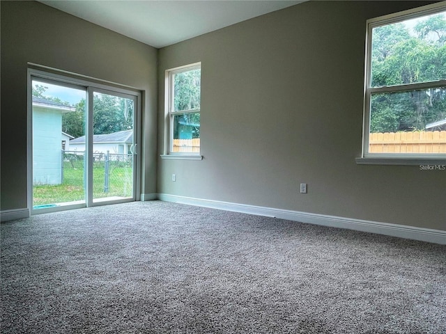 carpeted spare room featuring baseboards