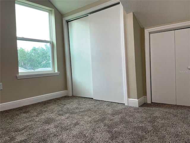 unfurnished bedroom with carpet floors, baseboards, and vaulted ceiling